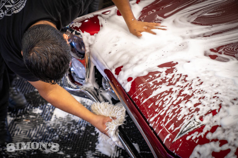 Washing the chrome grill of a 1967 Candy Apple Red Pontiac GTO.