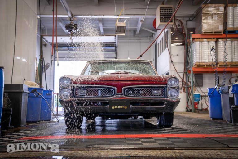 Snow foam being sprayed onto a 1967 Candy Apple Red Pontiac GTO.